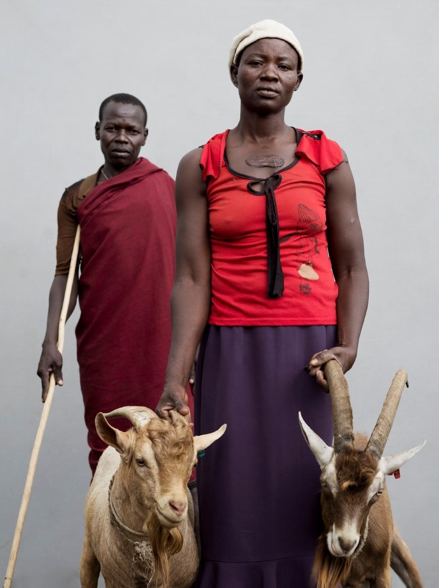 A participant in Farm Africa's Livestock for Livelihoods project in Uganda with her husband and the two bucks (male goats) she received from the project.