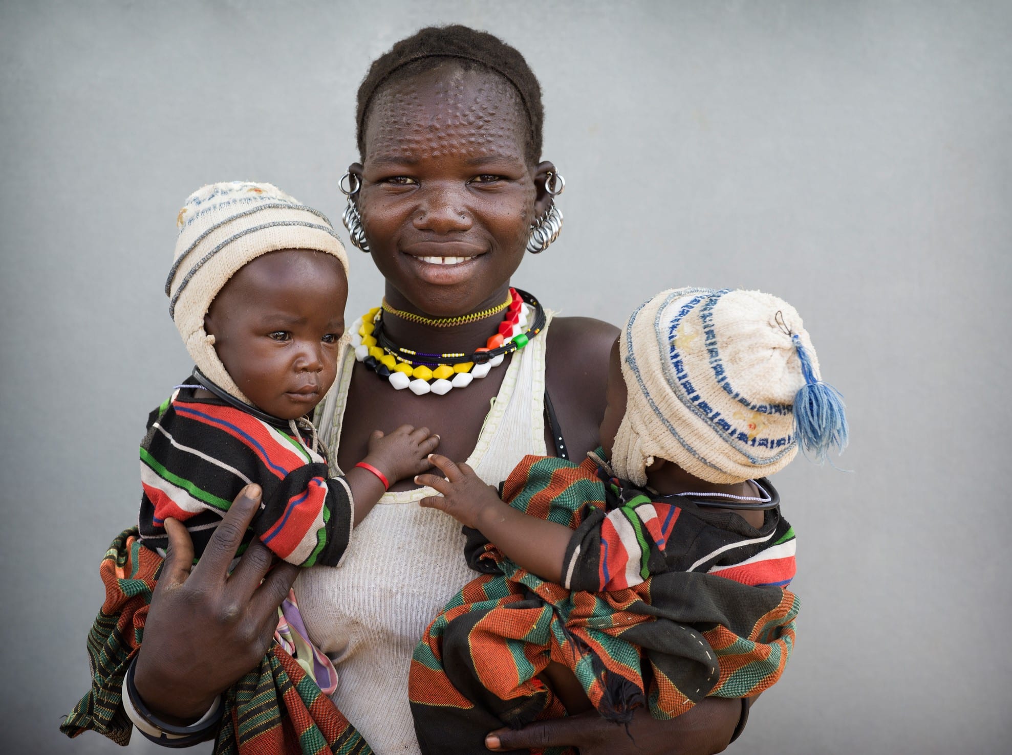 A mother in Uganda holding twin baby girls.