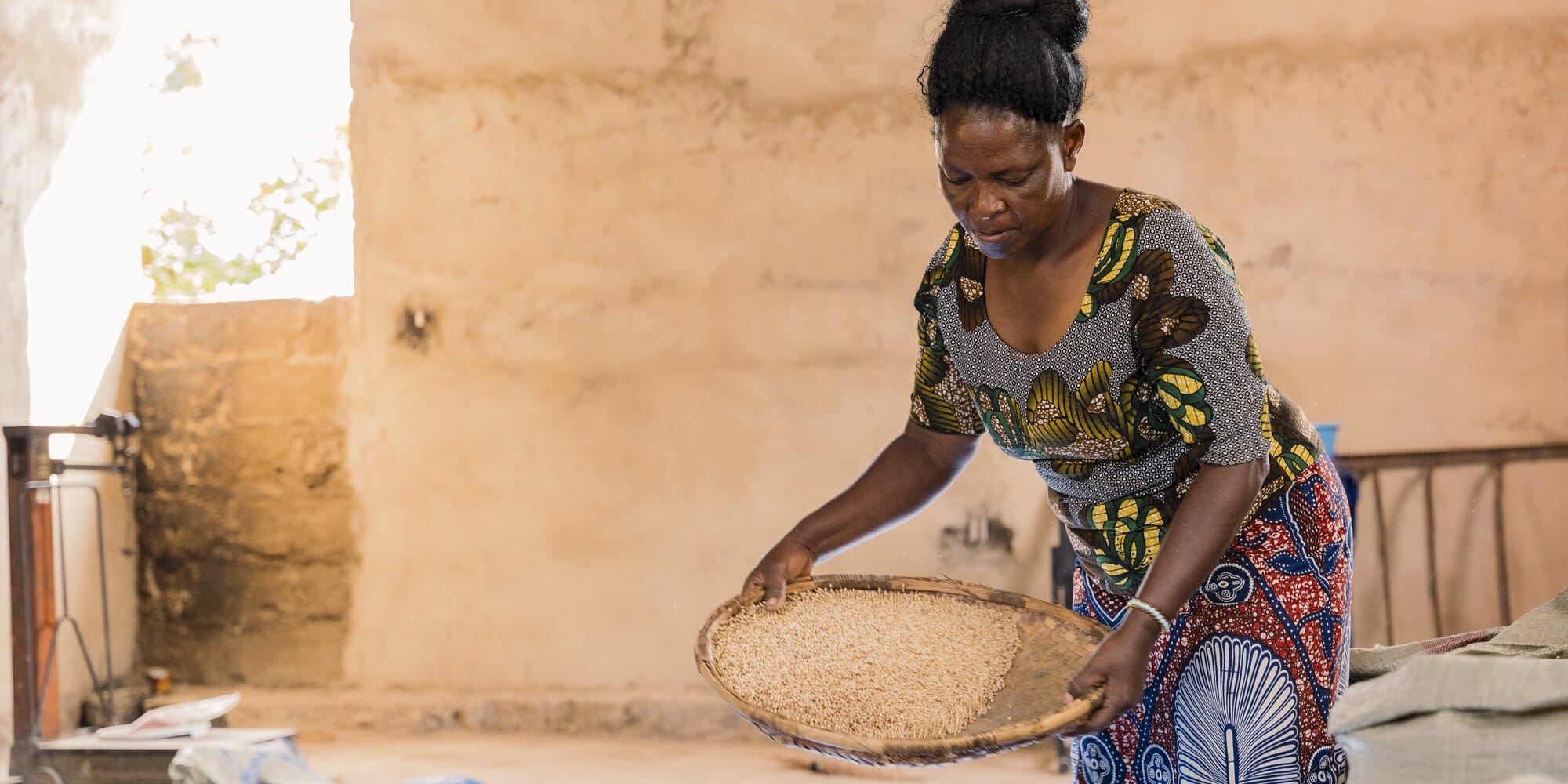 Elizabeth, a farmer in Tanzania, cleans and sorts quality declared sorghum seeds.